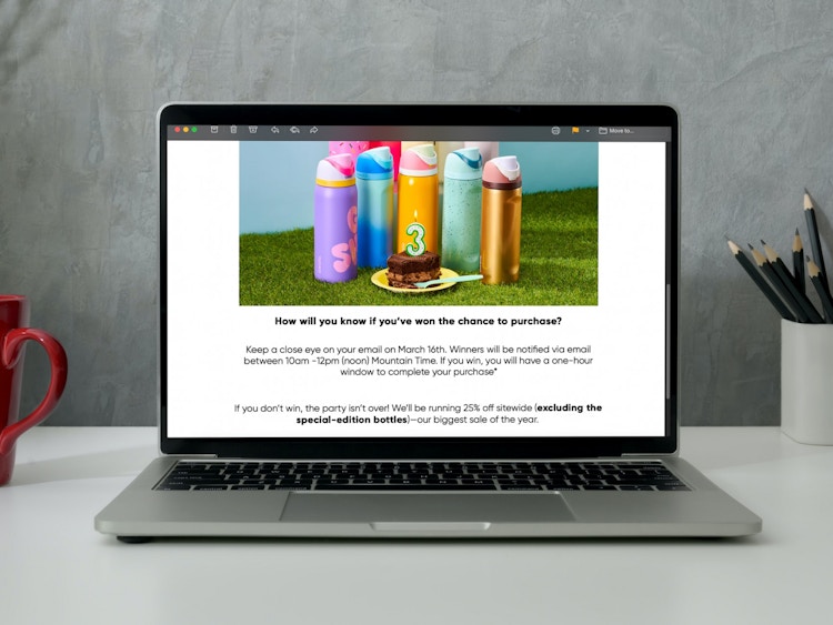 A laptop on a desk displaying an email about the Owala Special Edition bottle raffle