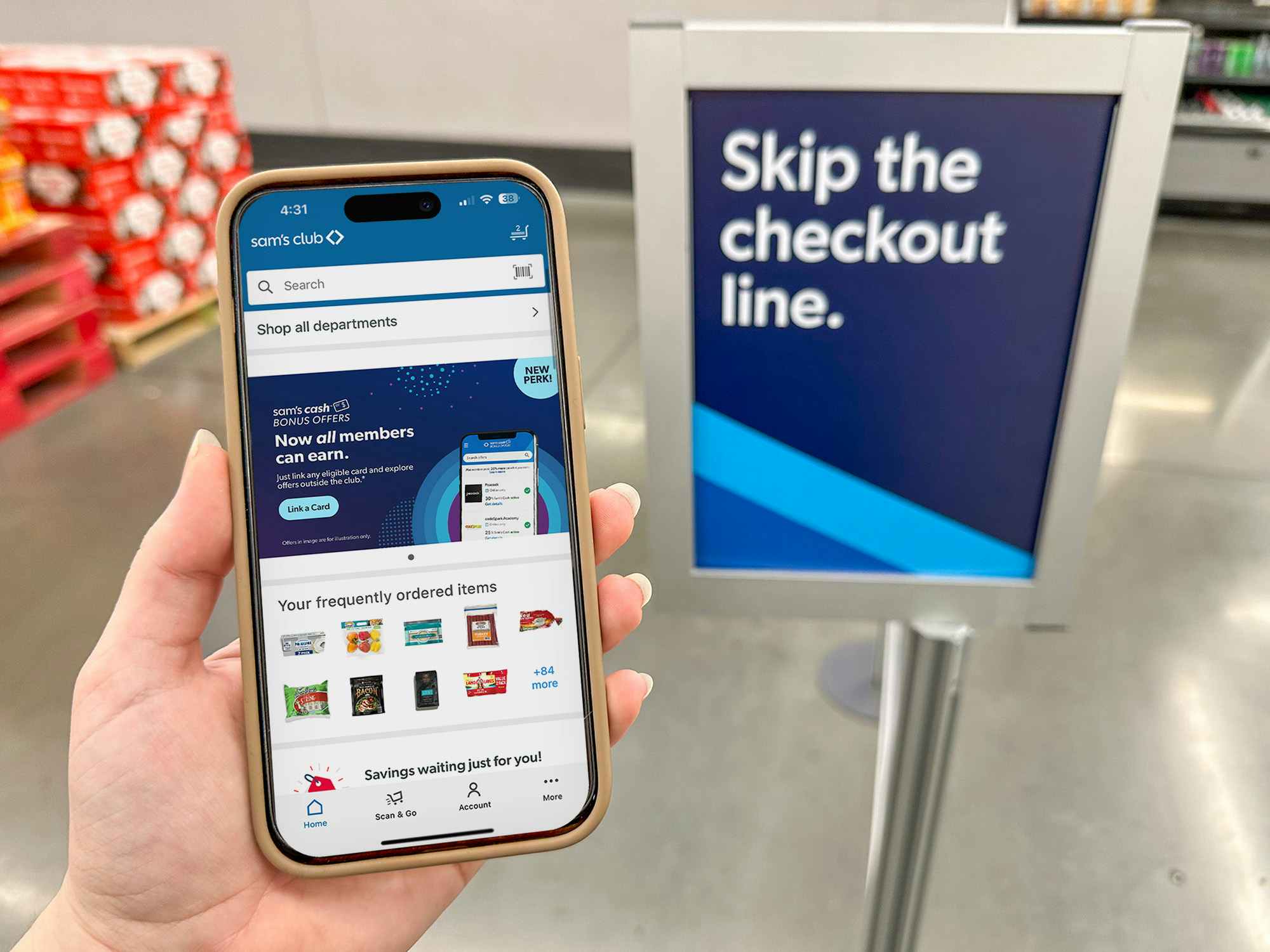 Someone holding up a phone displaying the Sam's Club app in front of the Sam's Club Scan and Go Fast Lane sign