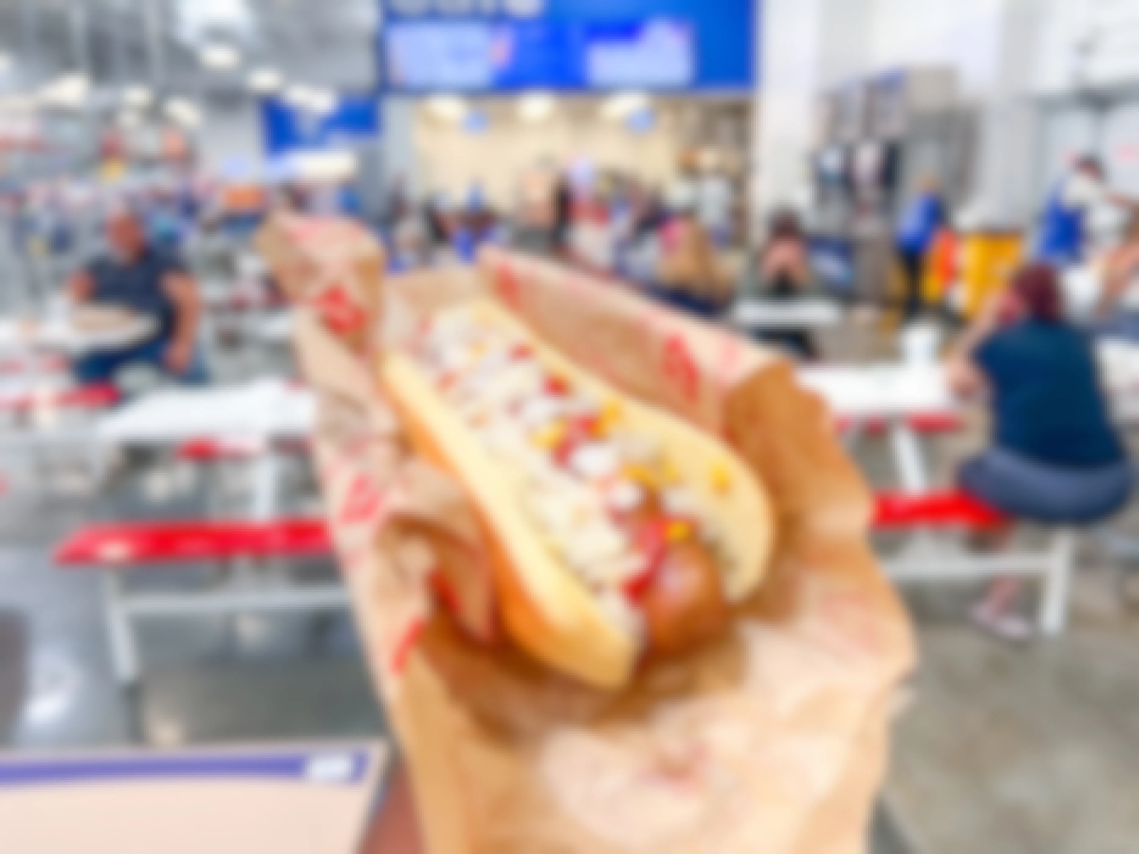 hand holding a Sam's Club Hot Dog inside the store