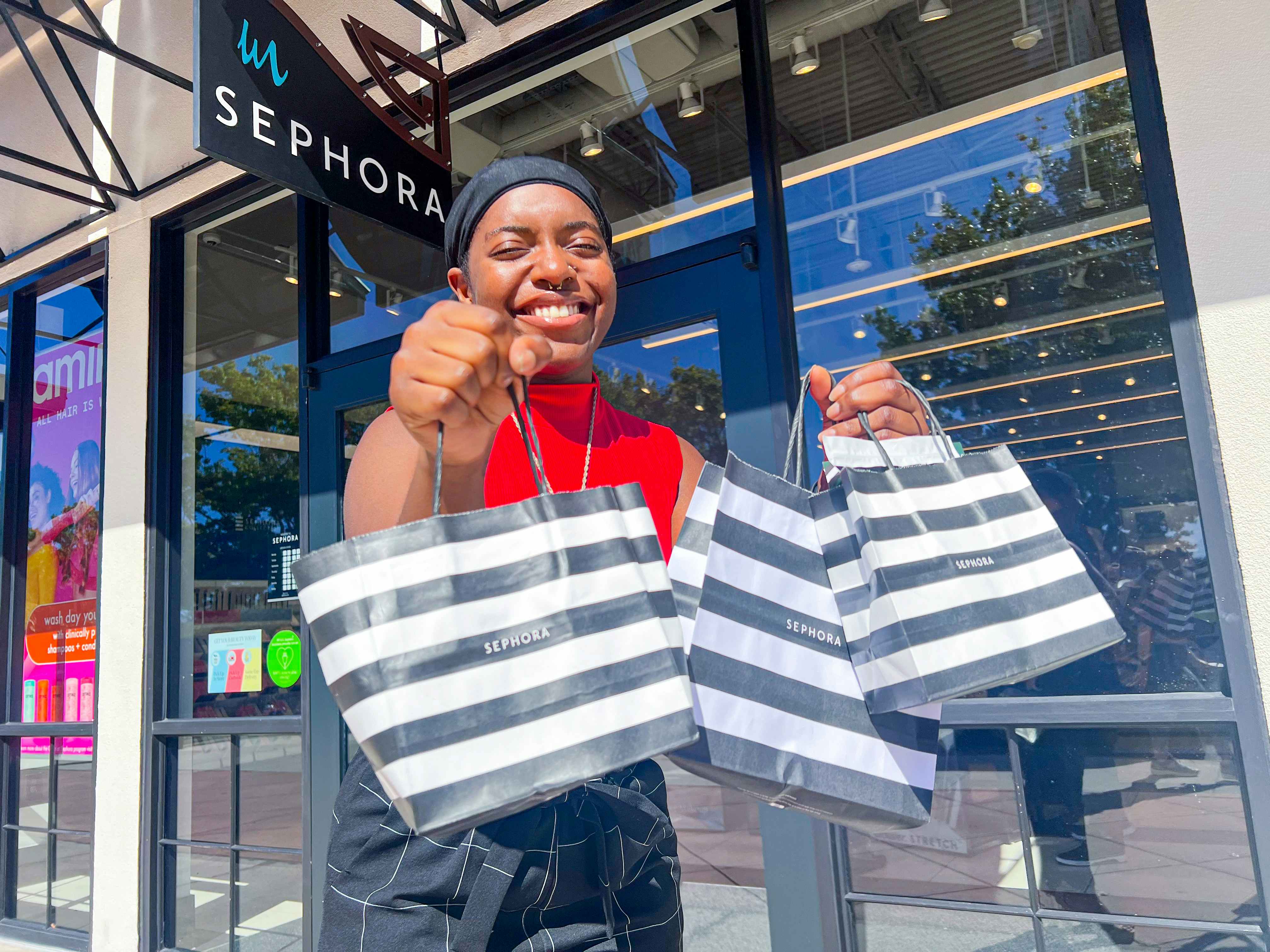 a person standing outside of sephora with shopping bag