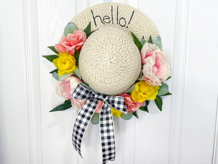 spring hat wreath hanging on door 
