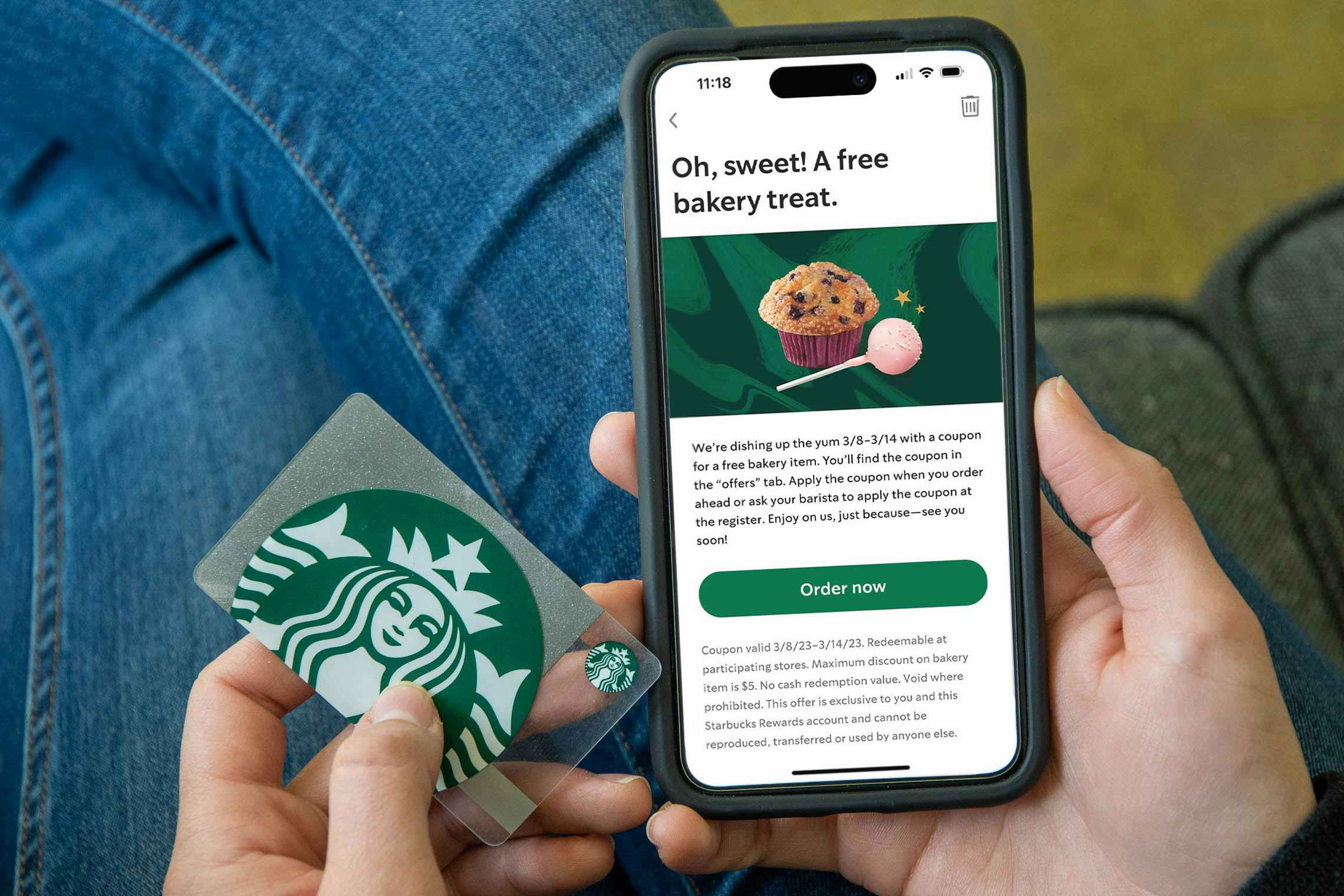 Someone holding a Starbucks card and a phone displaying an offer from Starbucks for a free bakery treat