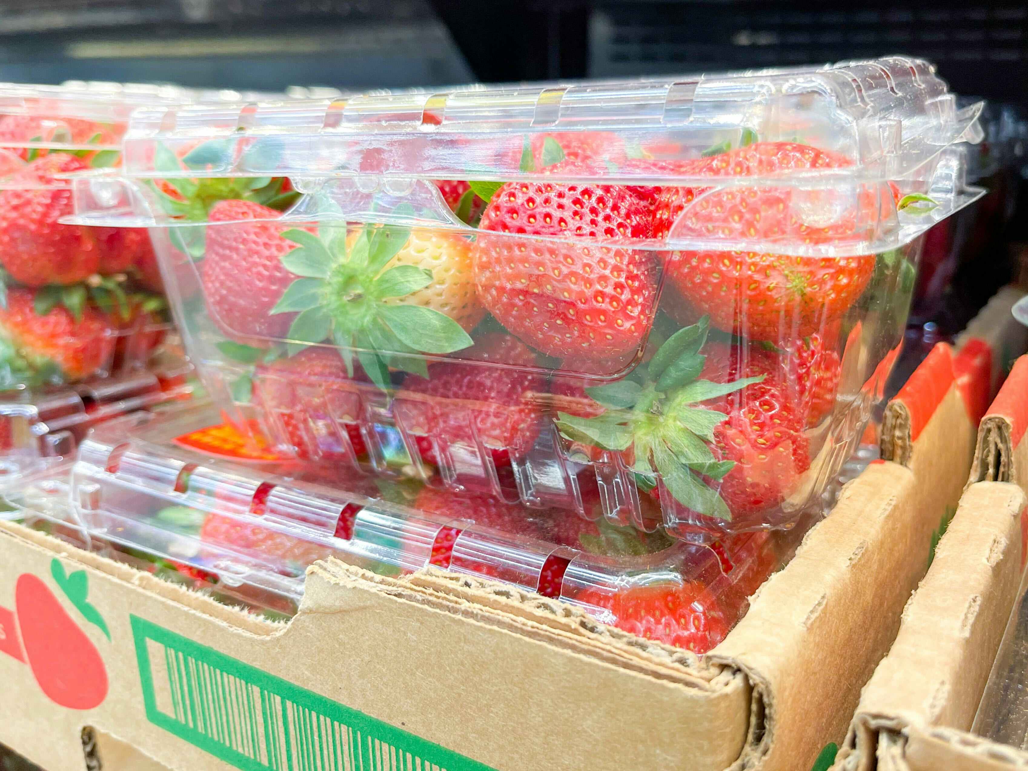 A box of strawberries sitting atop another box of strawberries.