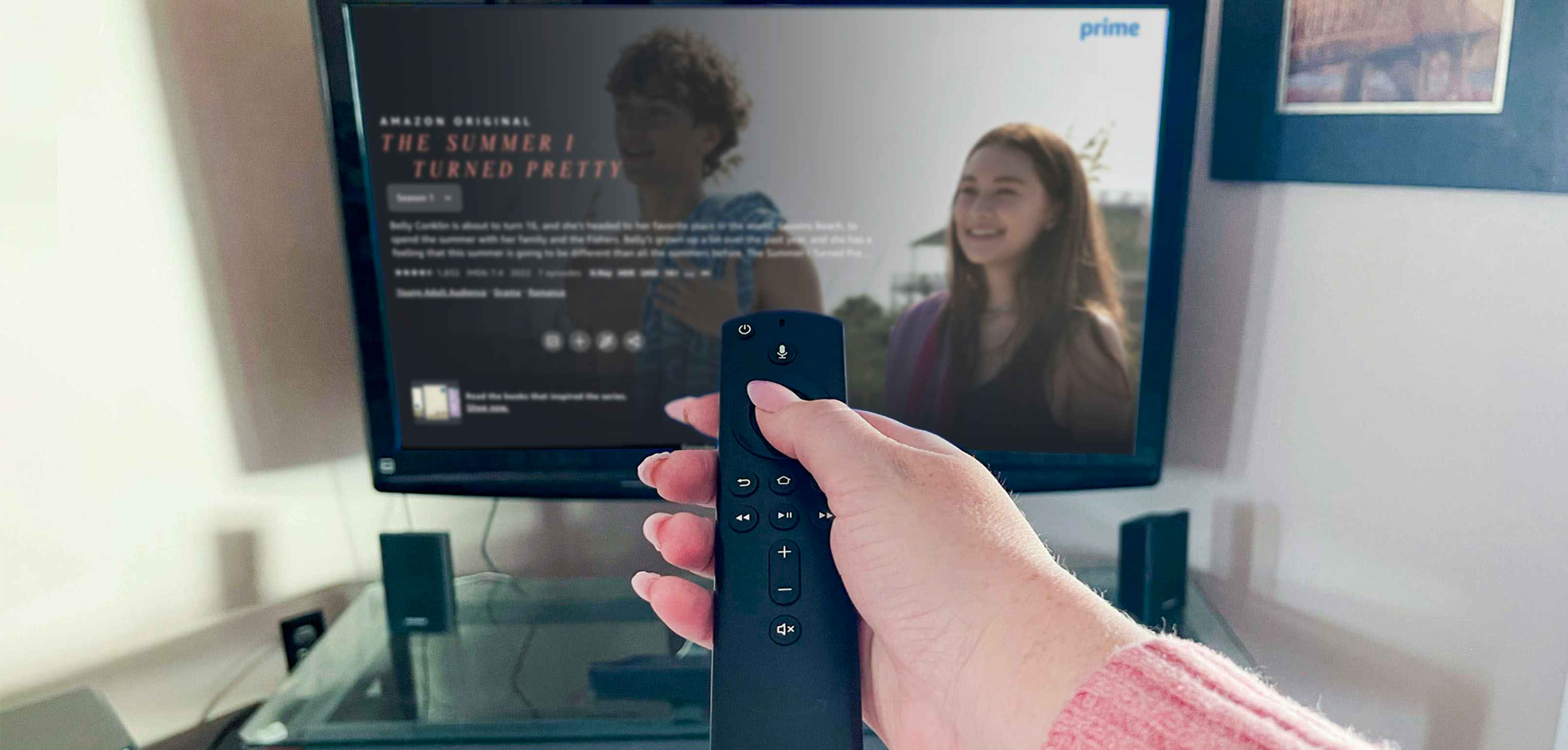 Hand holding a firestick remote pointed towards the tv screen