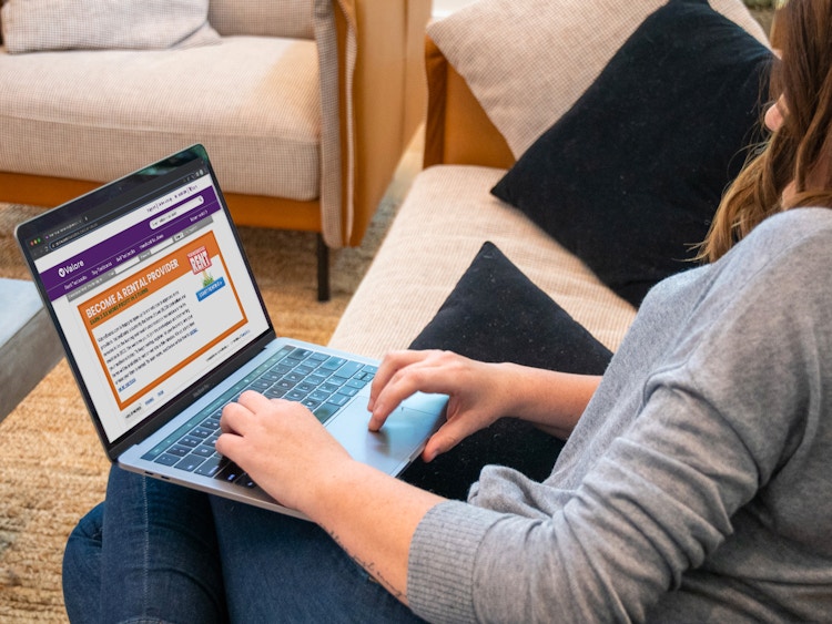 A woman looking at the Valore book rental website on her laptop