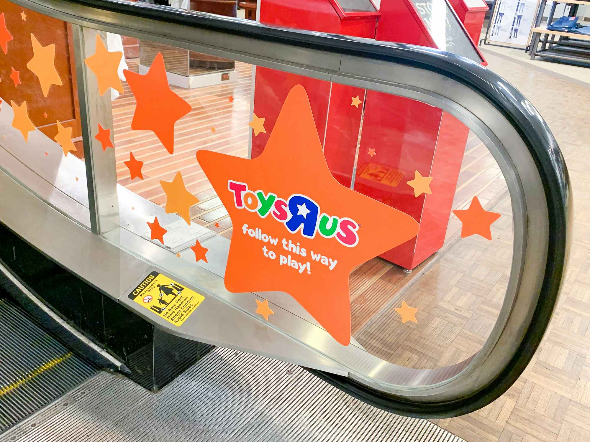 toys r us signage on macys store escalator
