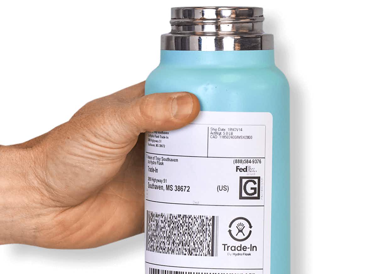 hand holding hydro flask with attached return label for trade-in program
