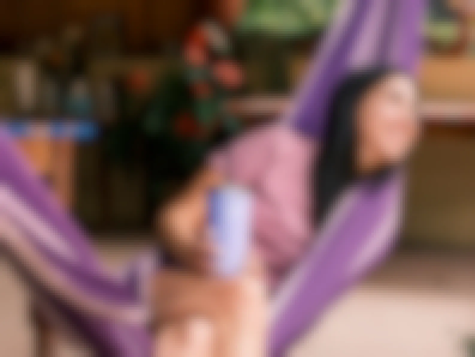 happy person in hammock holding purple hydro flask bottle