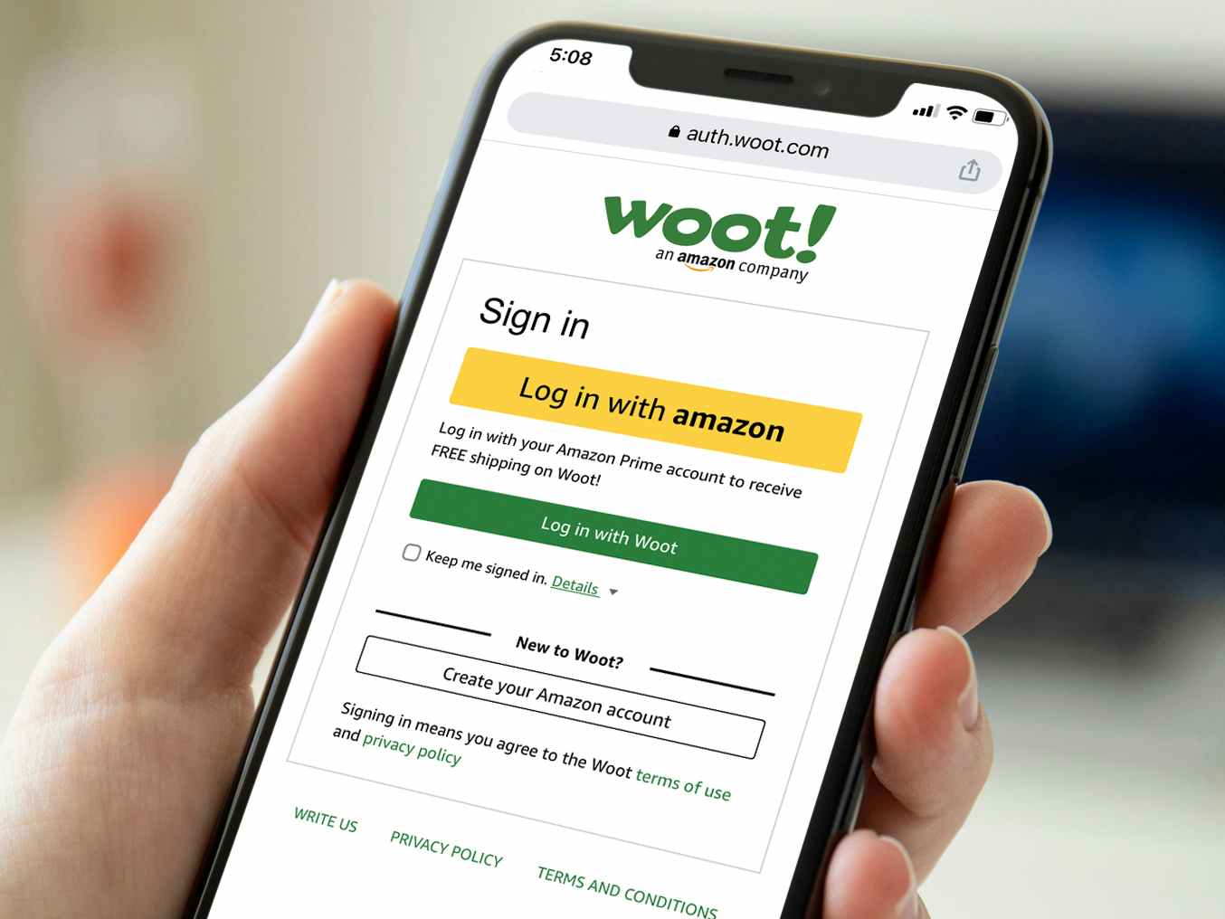 person holding phone with woot login screen
