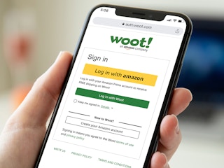 person holding phone with woot login screen
