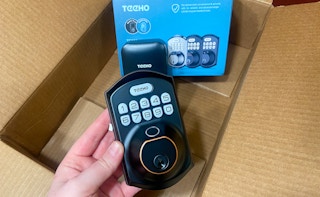 hand holding a teeho keyless entry keypad fingerprint door lock