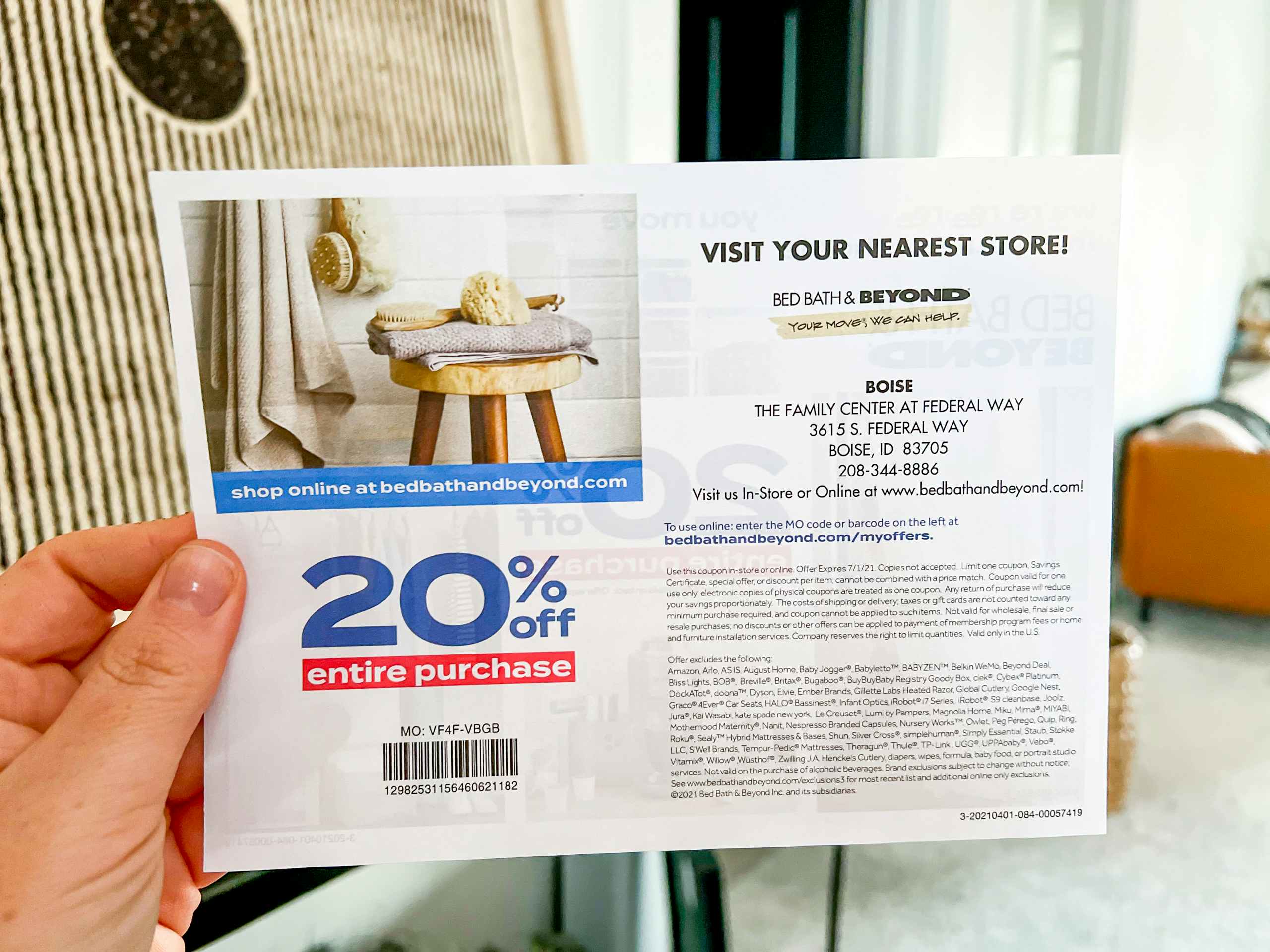 a person holding a bed bath and beyond coupon