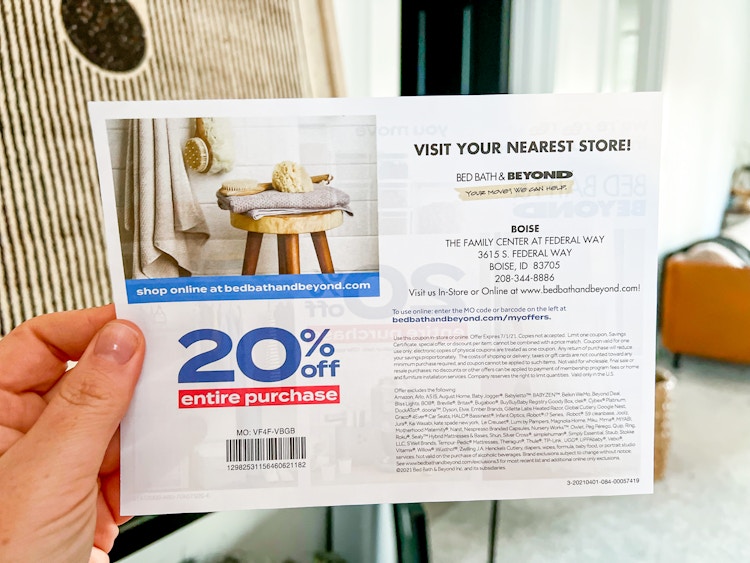 a person holding a bed bath and beyond coupon