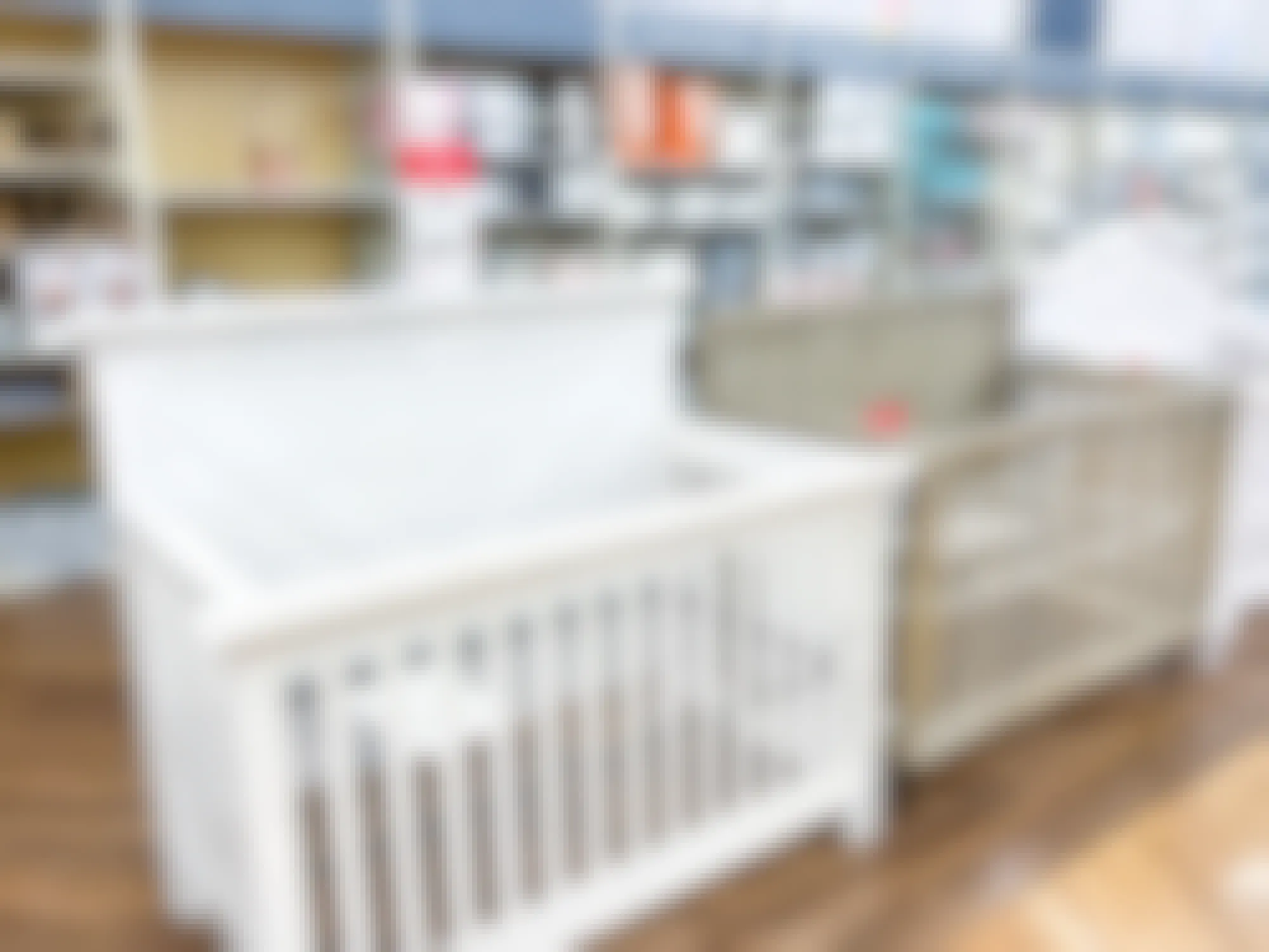 several baby cribs on display at a buybuy baby store