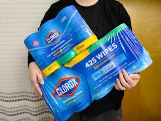 Someone holding some multi-packs of disinfectant wipes