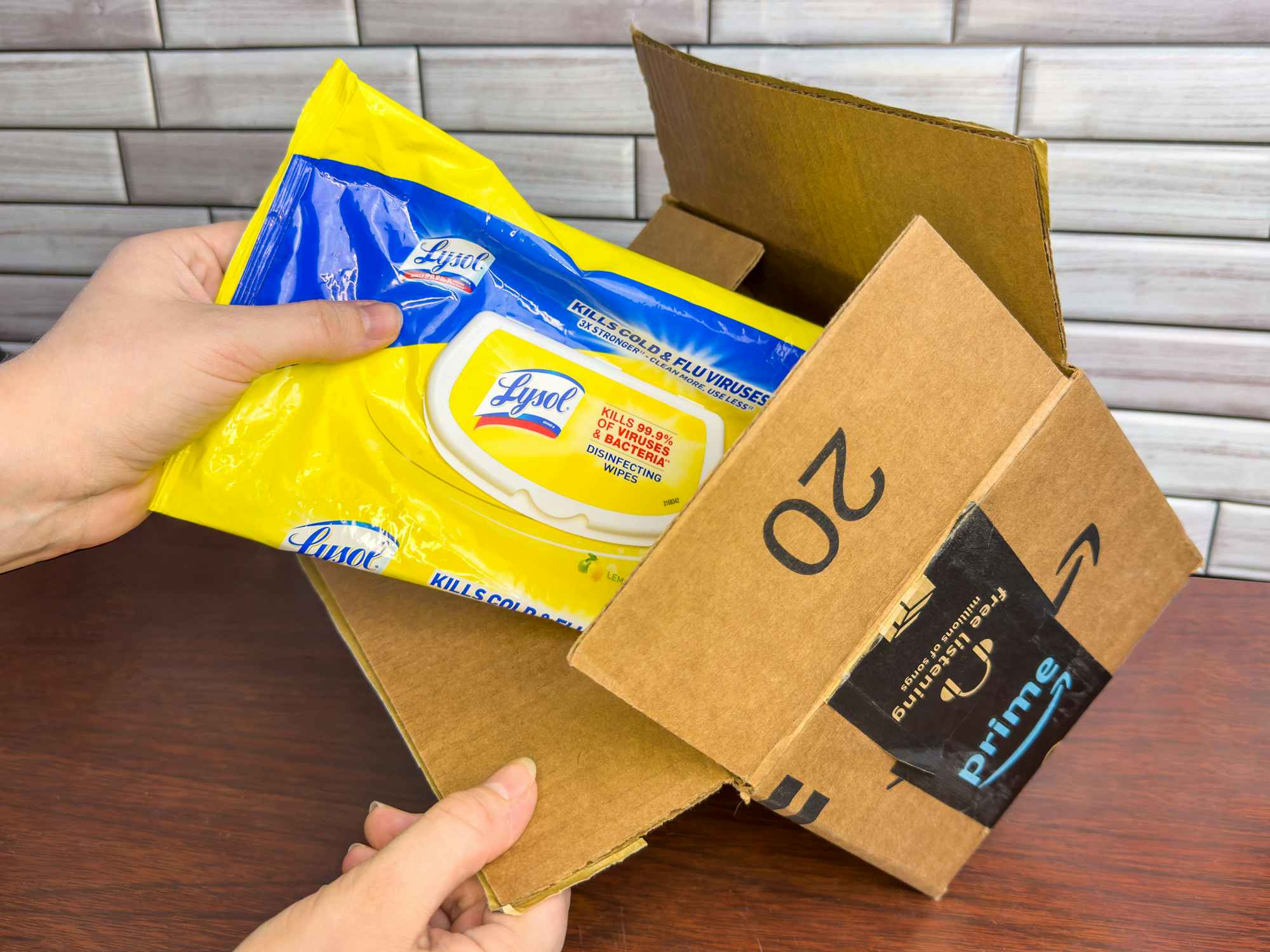 Someone pulling some Lysol wipes out of an Amazon box
