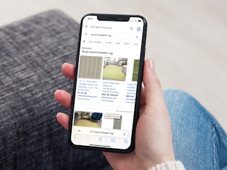 a person on their iphone looking at google shopping for rugs