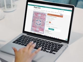 a person on their macbook looking at rugs.com