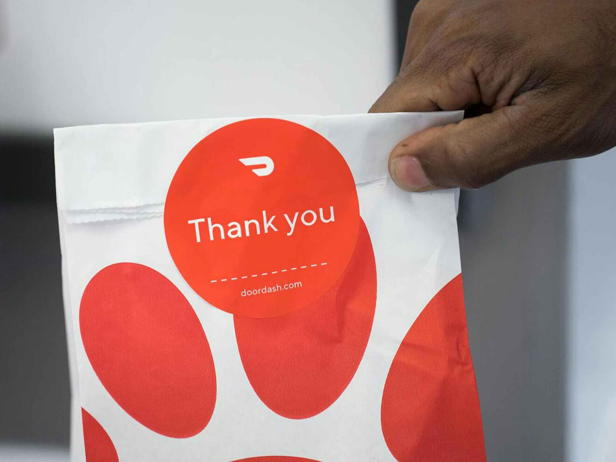 a hand holding a to-go Chick-fil-A bag that says thank you