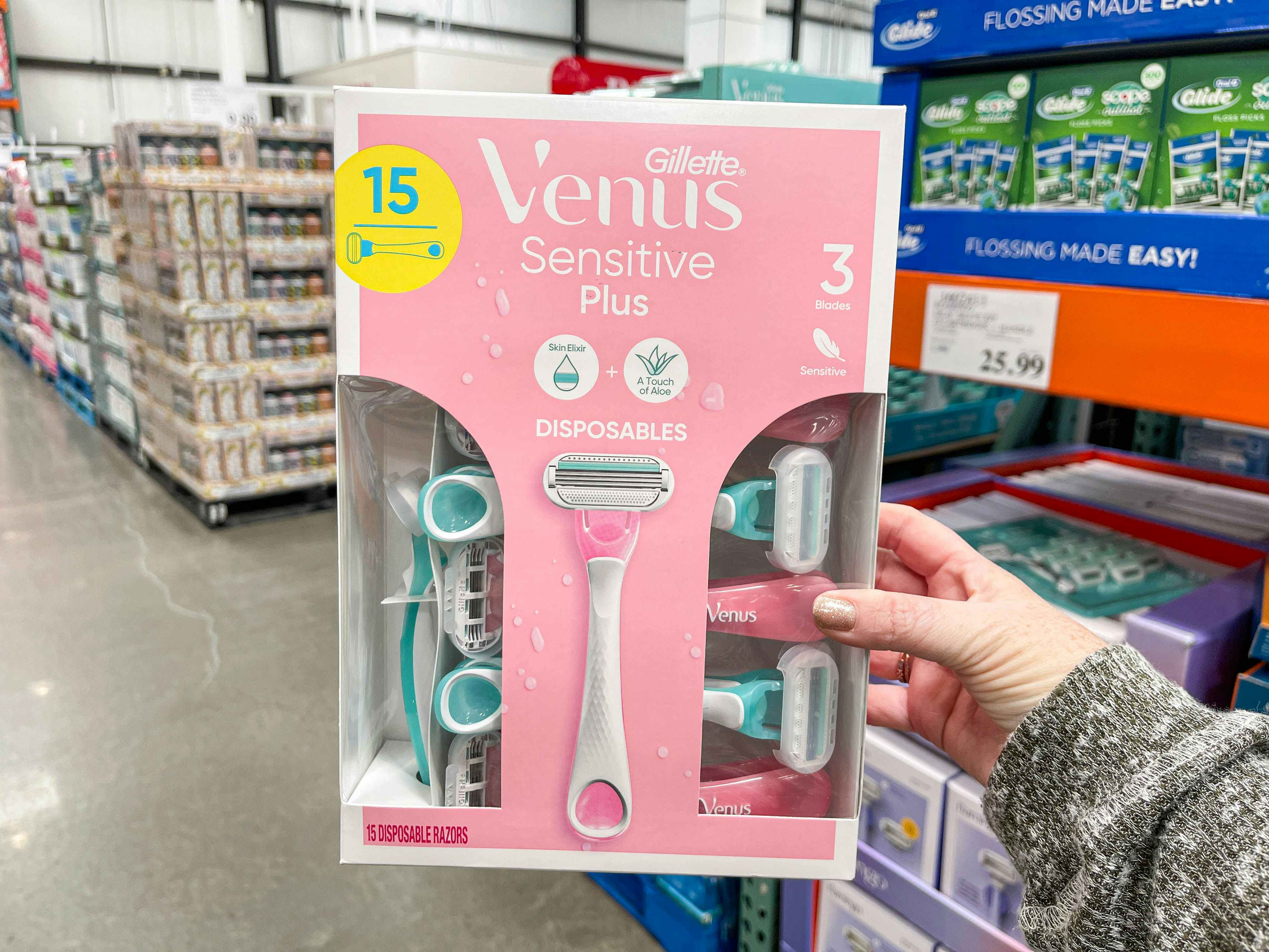 a person holding up a pack of razors in store 