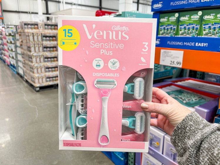 a person holding up a pack of razors in store 