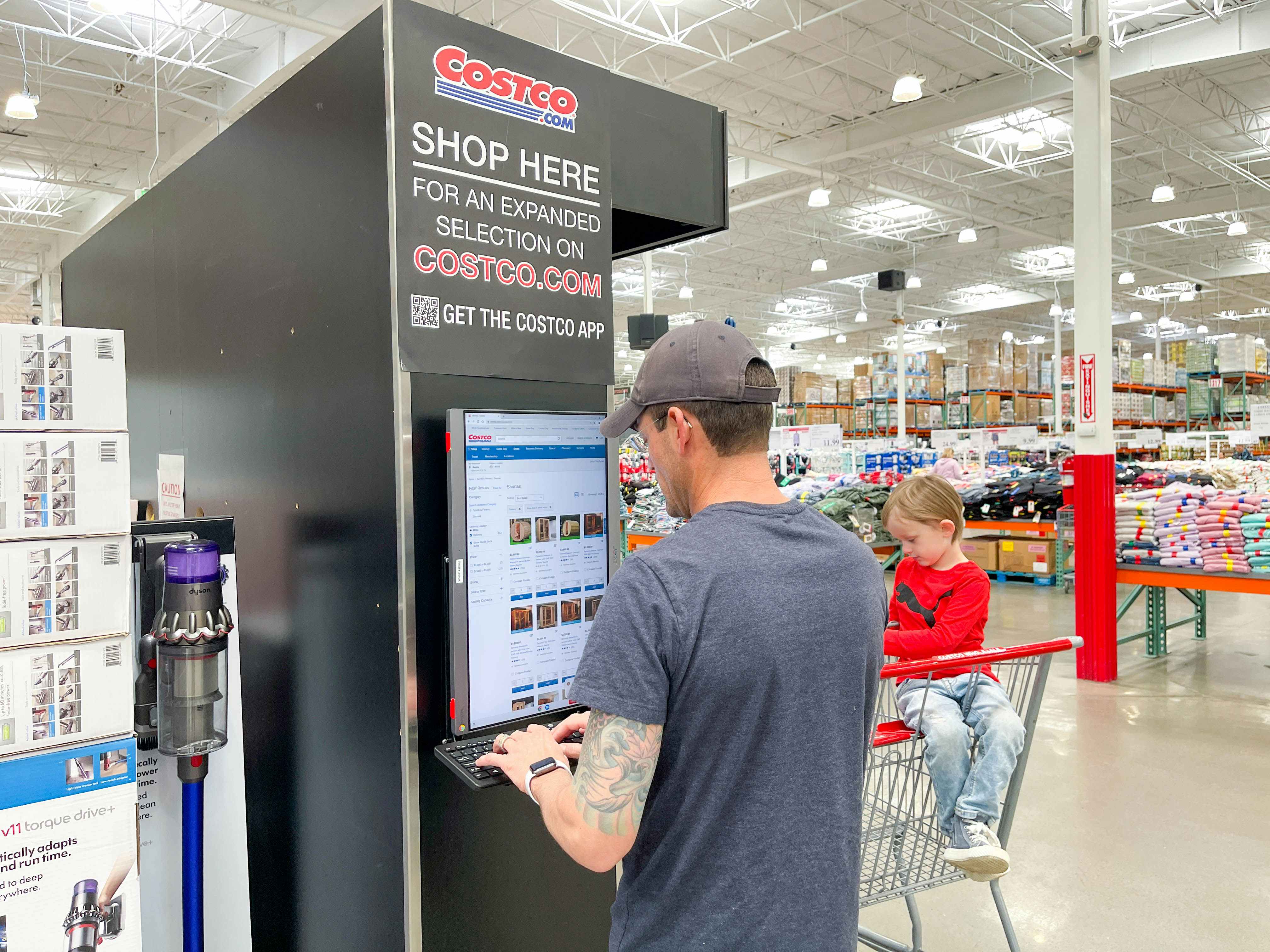 a man looking at the costco online screen in store