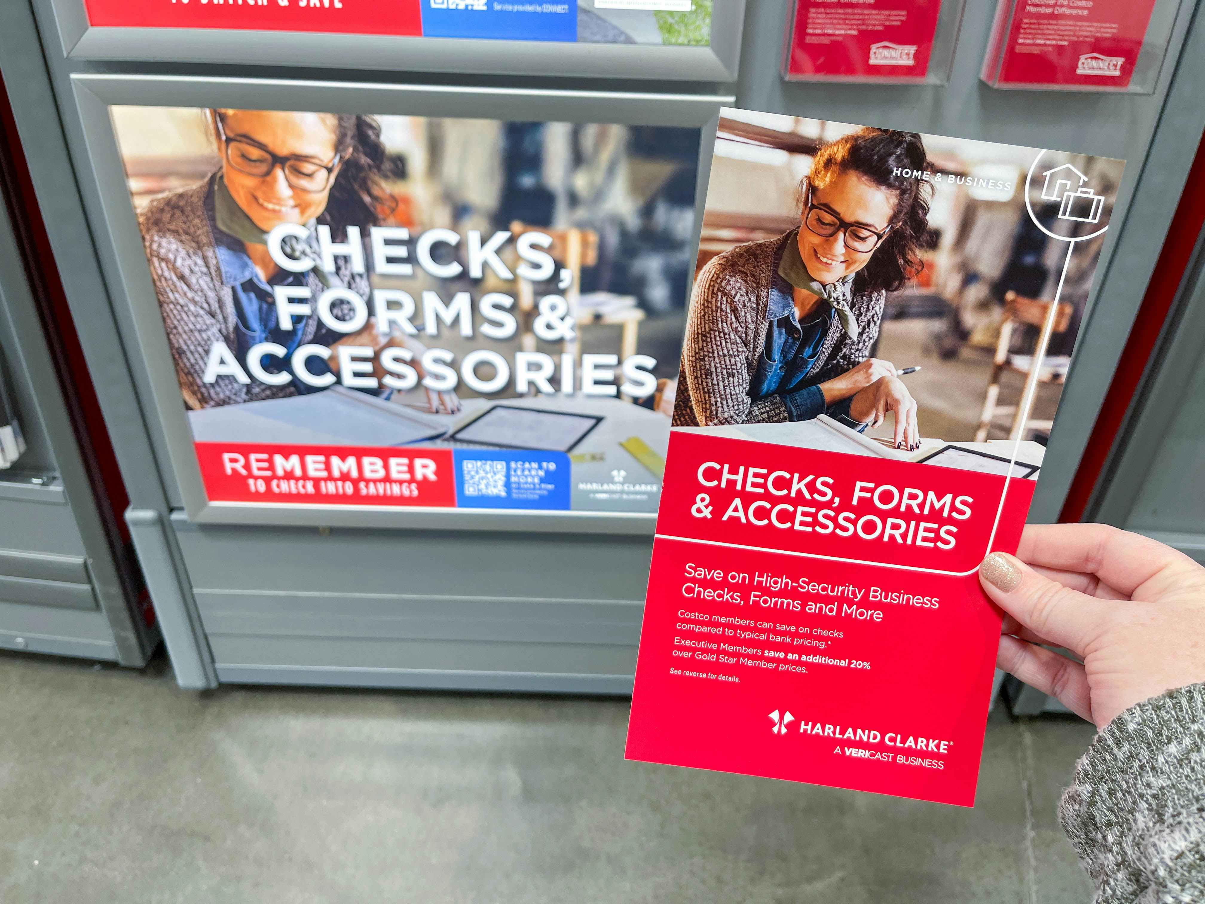 a person holding up a brochure for costco check and forms 