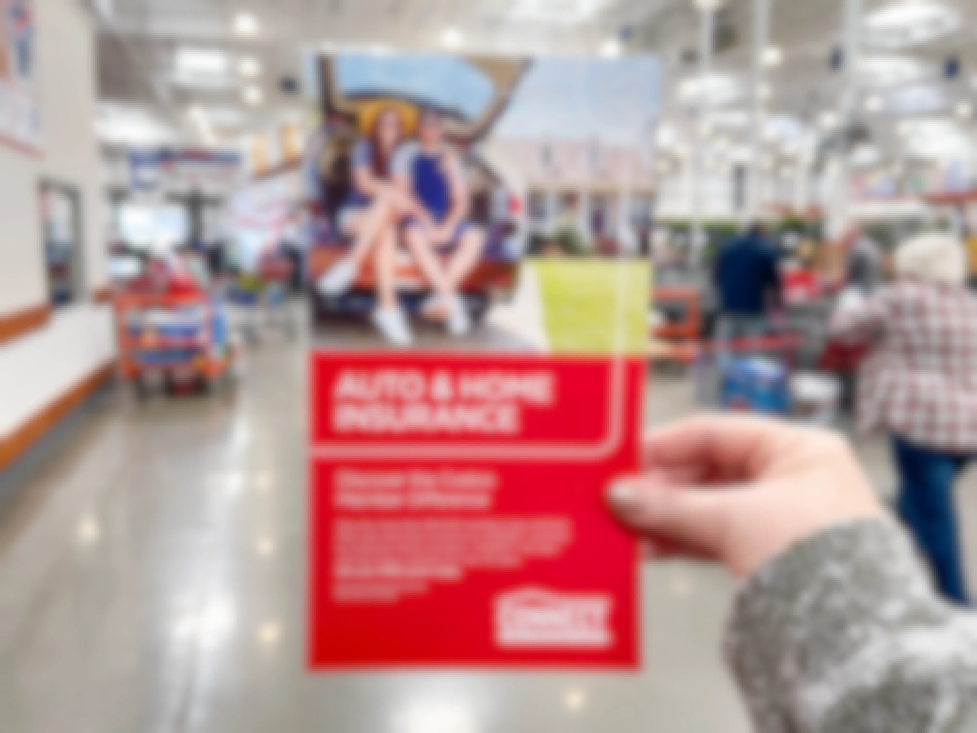 a person holding up a brochure for costco auto and home insurance