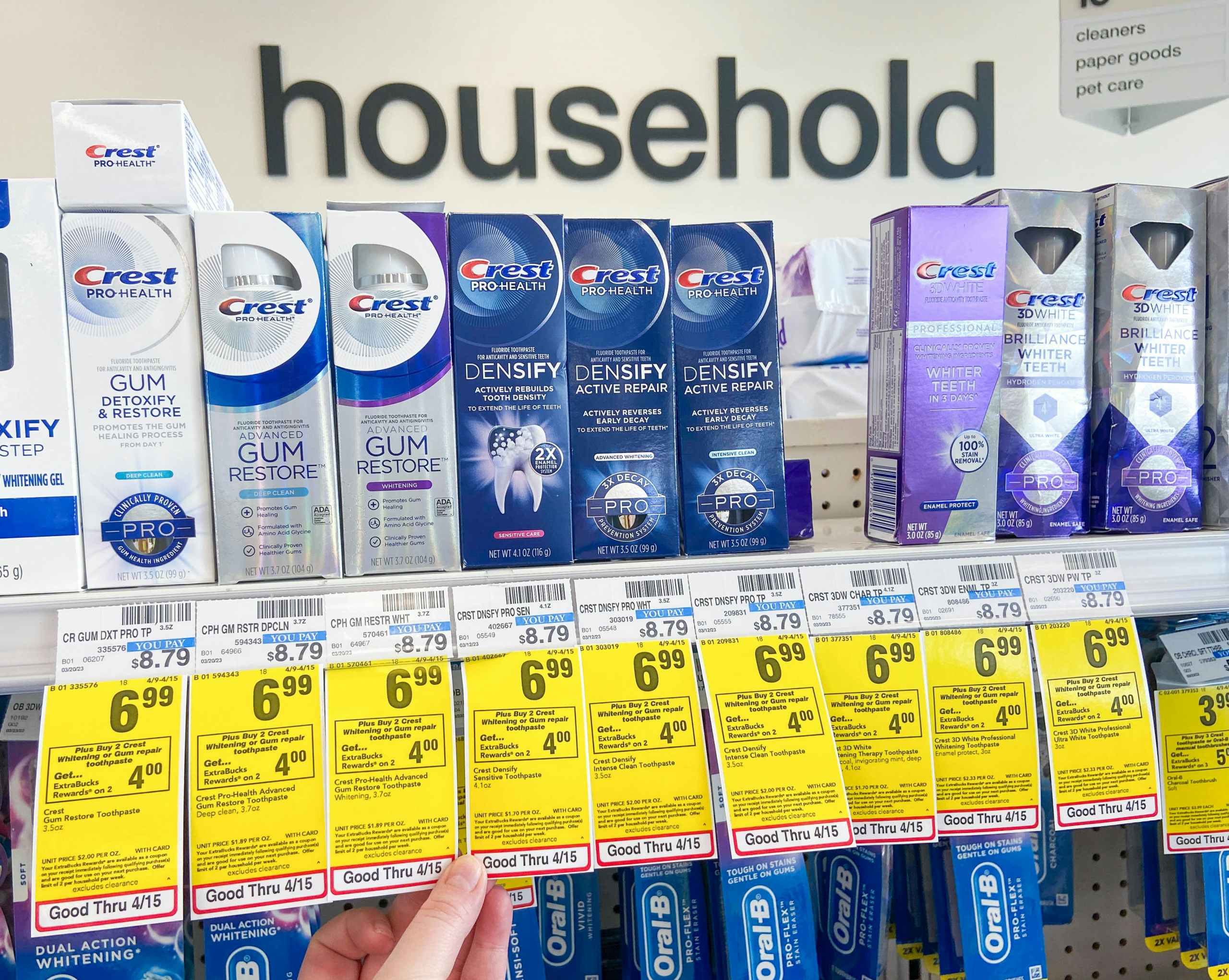 boxes of Crest premium toothpaste on shelf with sales tag underneath