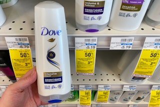 hand holding dove hair care bottle next to store sale tag