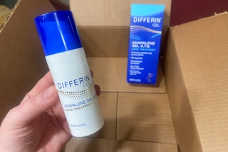 hand holding differin adapalene retinoid acne gel over an amazon box