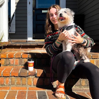 person on the steps of carpe diem coffee and tea company with dog