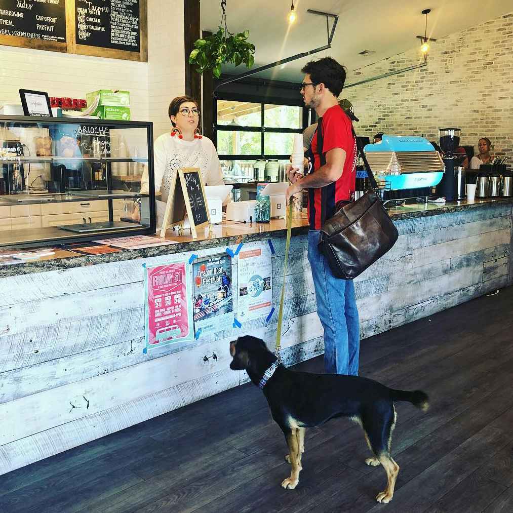 red bicycle coffee and crepes customer with dog at counter and barista