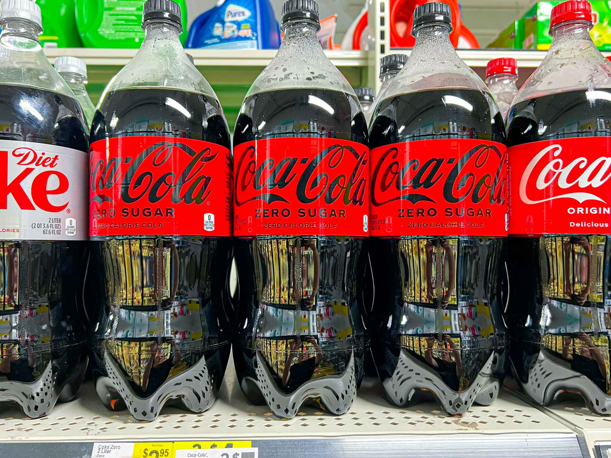 2L bottles of Coca Cola stocked on a shelf at Dollar General