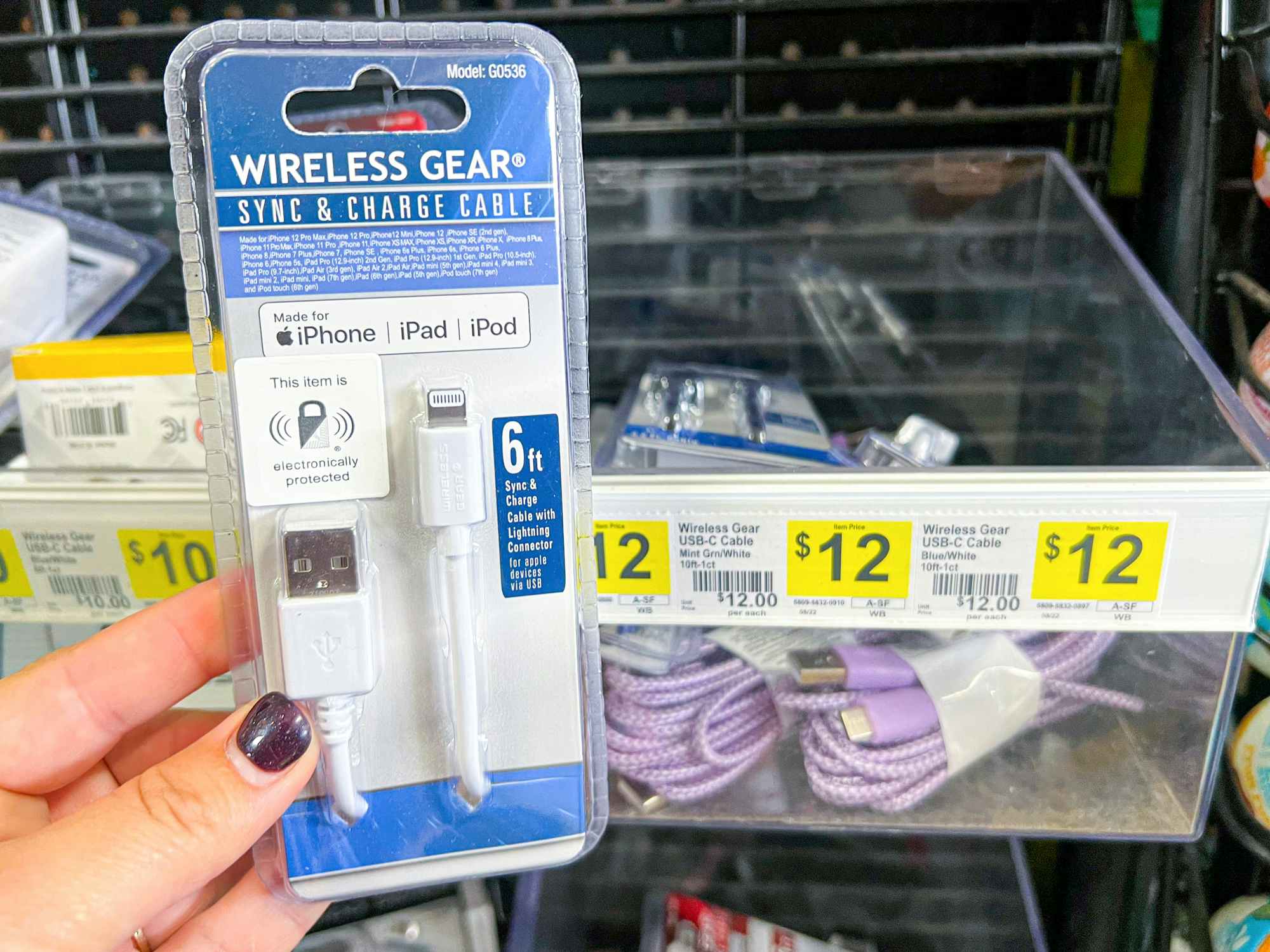 Someone holding up a Wireless Gear iPhone charger next to a shelf at Dollar General