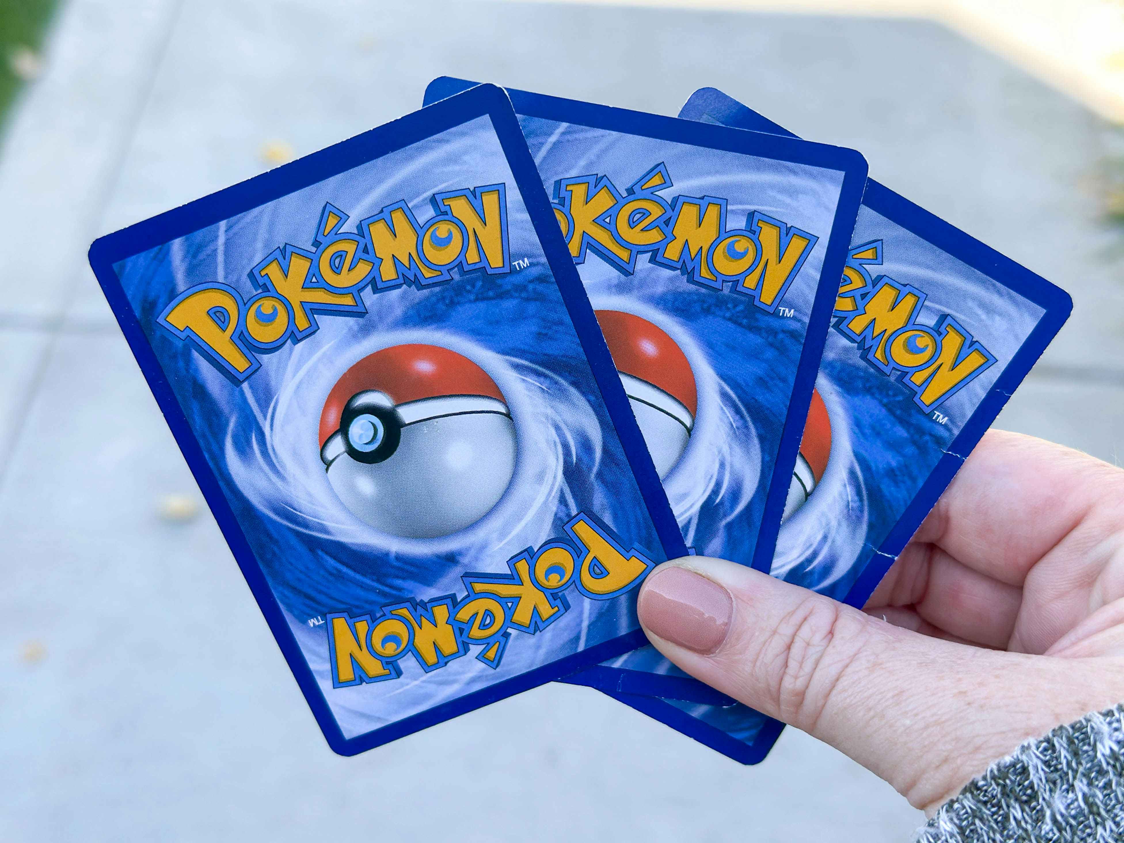pokemon cards being held 