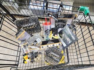 graduation party supplies in a cart