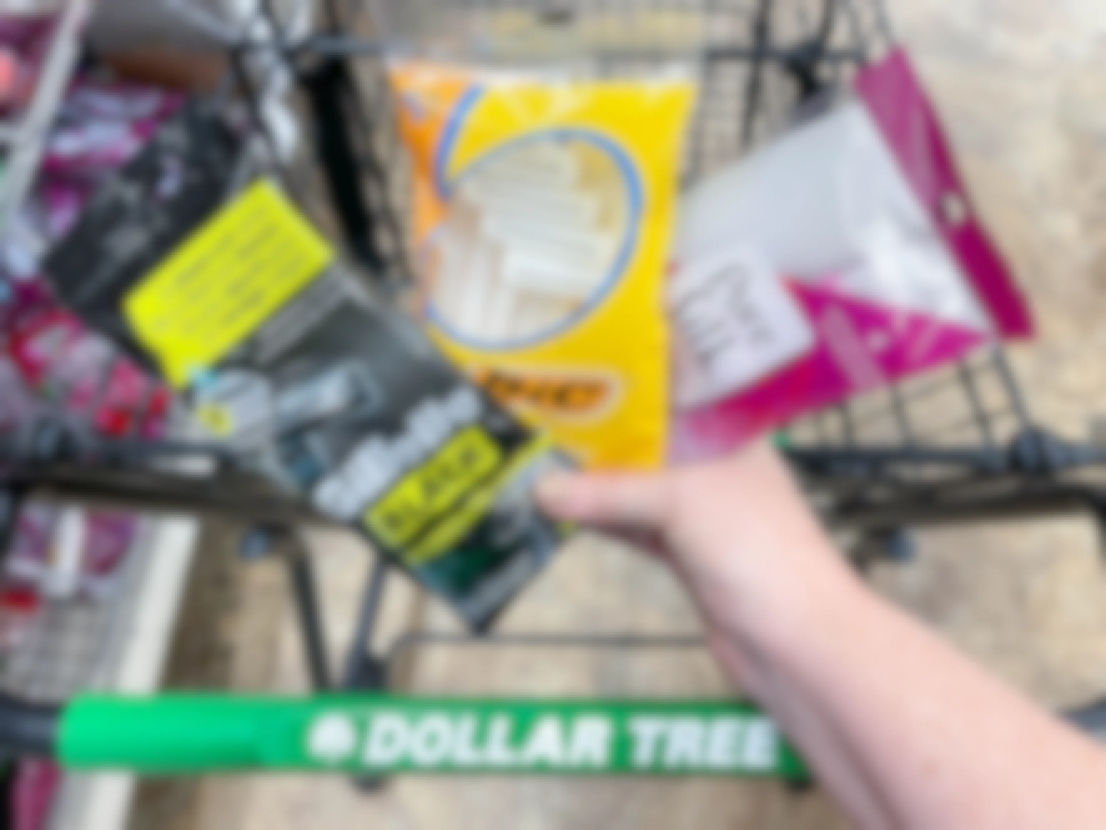 a person holding razor packages in front of dollar tree cart