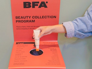 a person recycling an empty makeup bottle