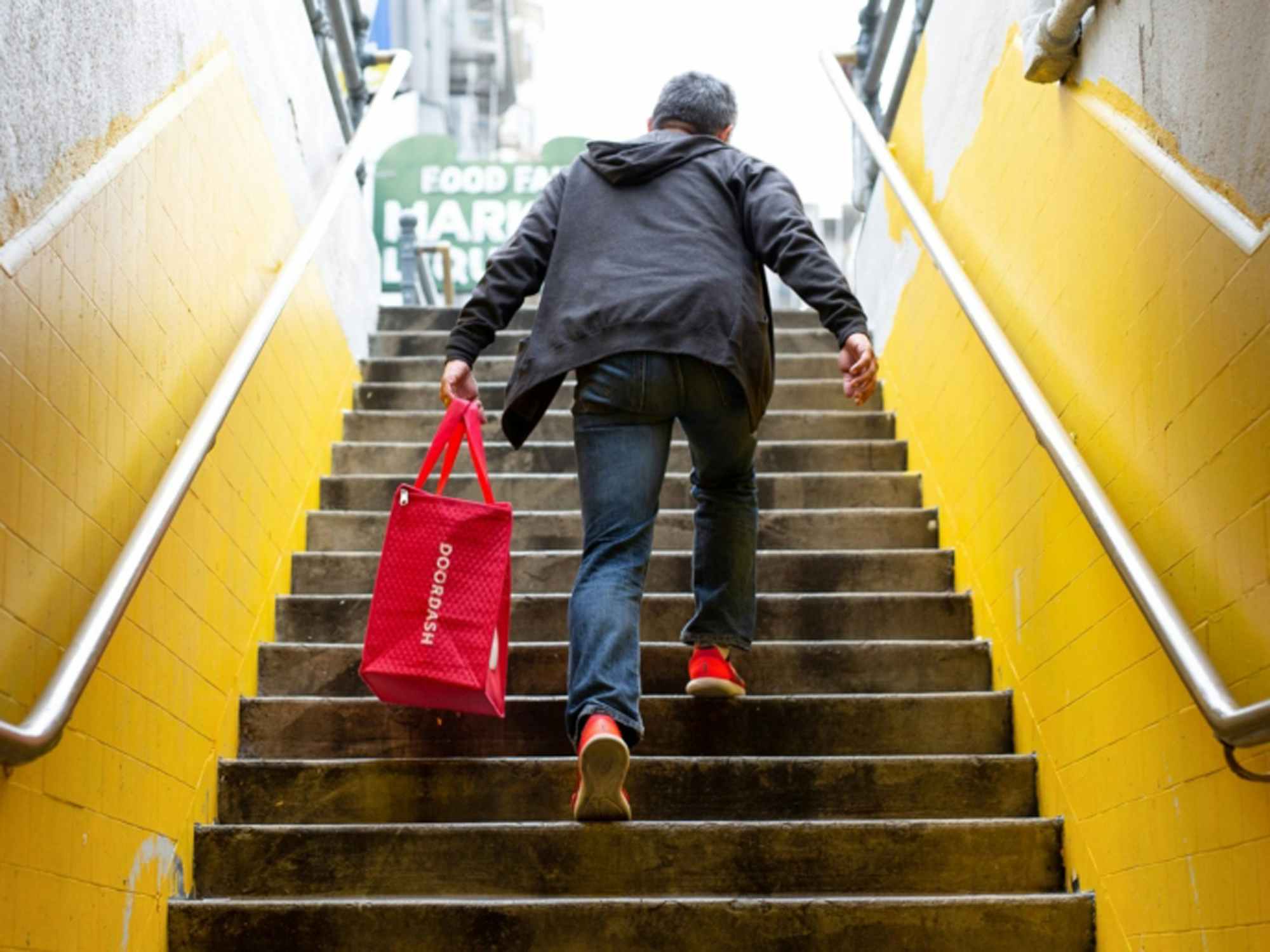a person walking up stairs with a doordash bag