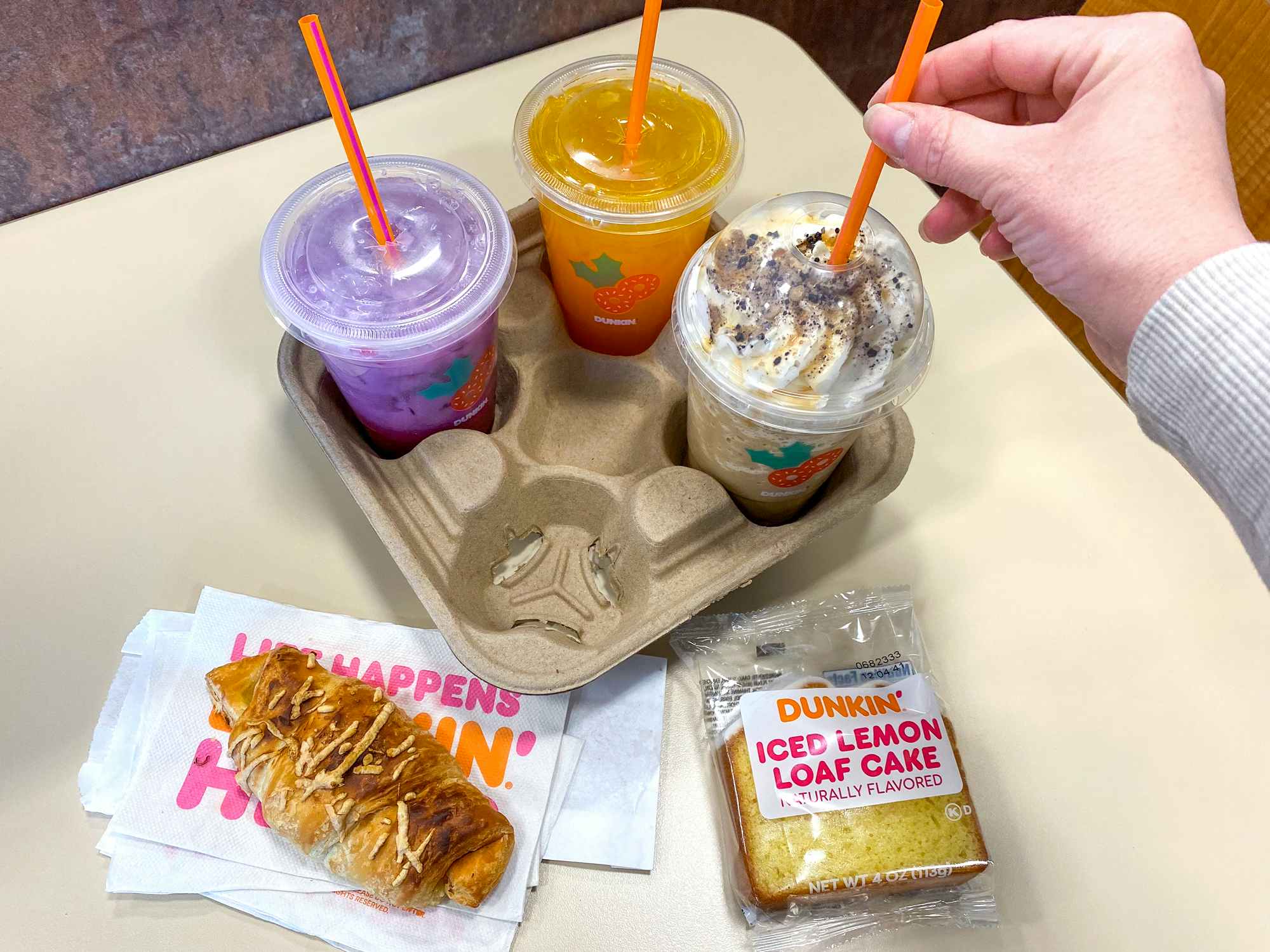 dunkin donuts refreshers, croissant stuffer, iced lemon loaf cake, and frozen butter pecan swirl drink in restaurant
