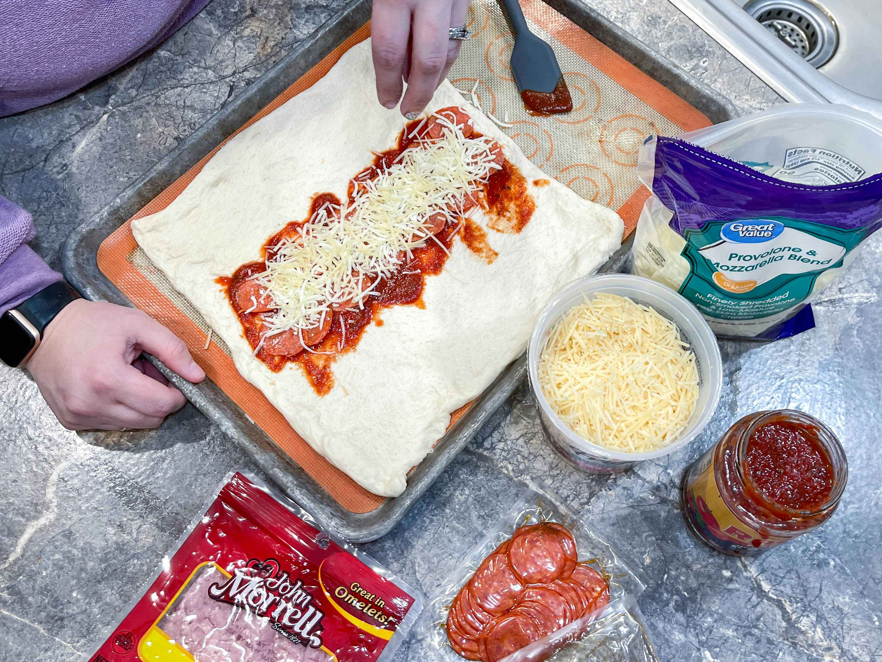 stromboli being made on a baking sheet 