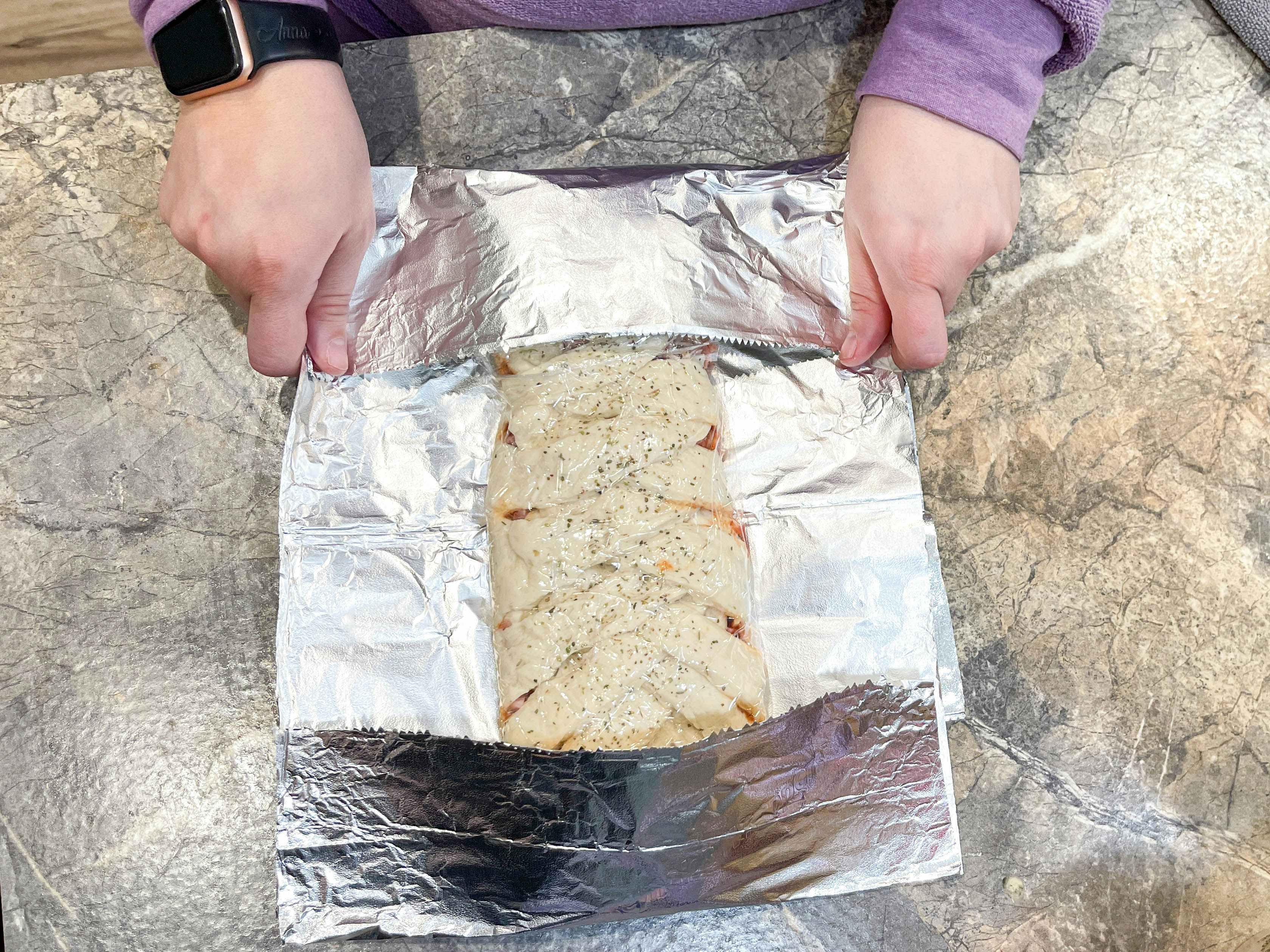 stromboli being wrapped in foil to freeze