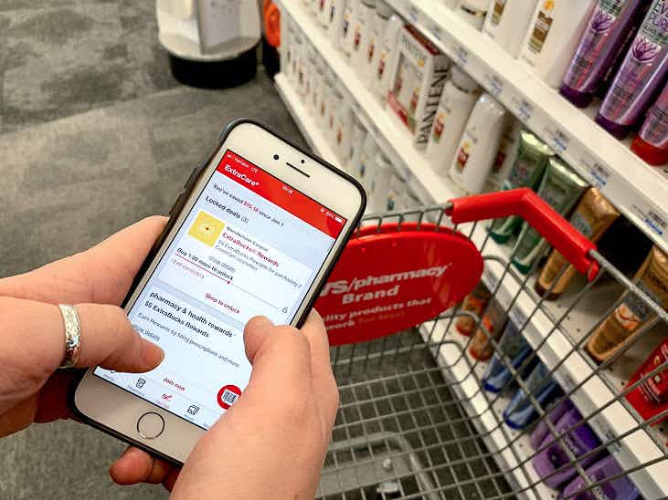 woman holds phone with cvs pharmacy app on screen