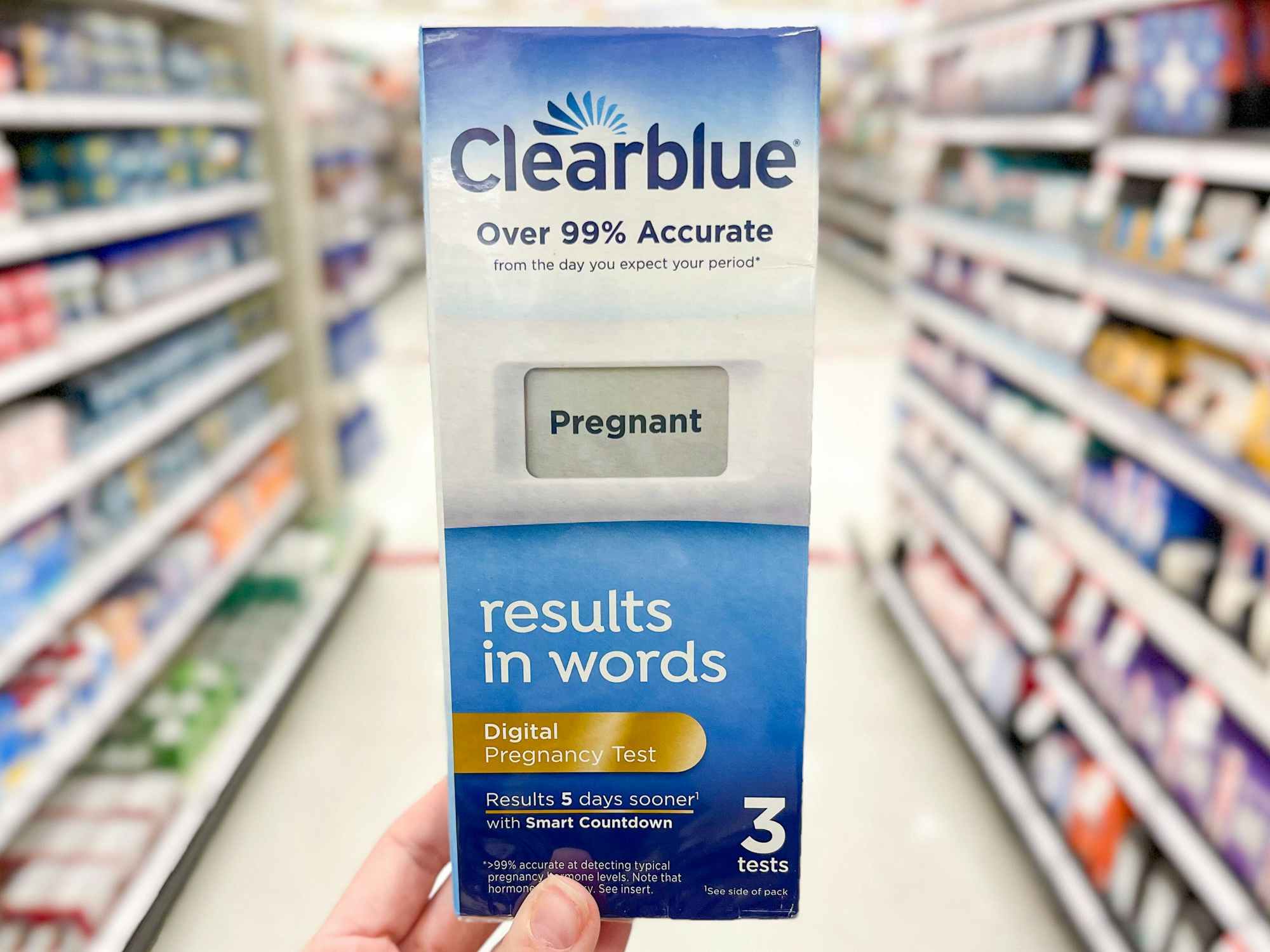 Someone holding a box of Clearblue pregnancy tests in a store
