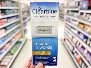 Someone holding a box of Clearblue pregnancy tests in a store