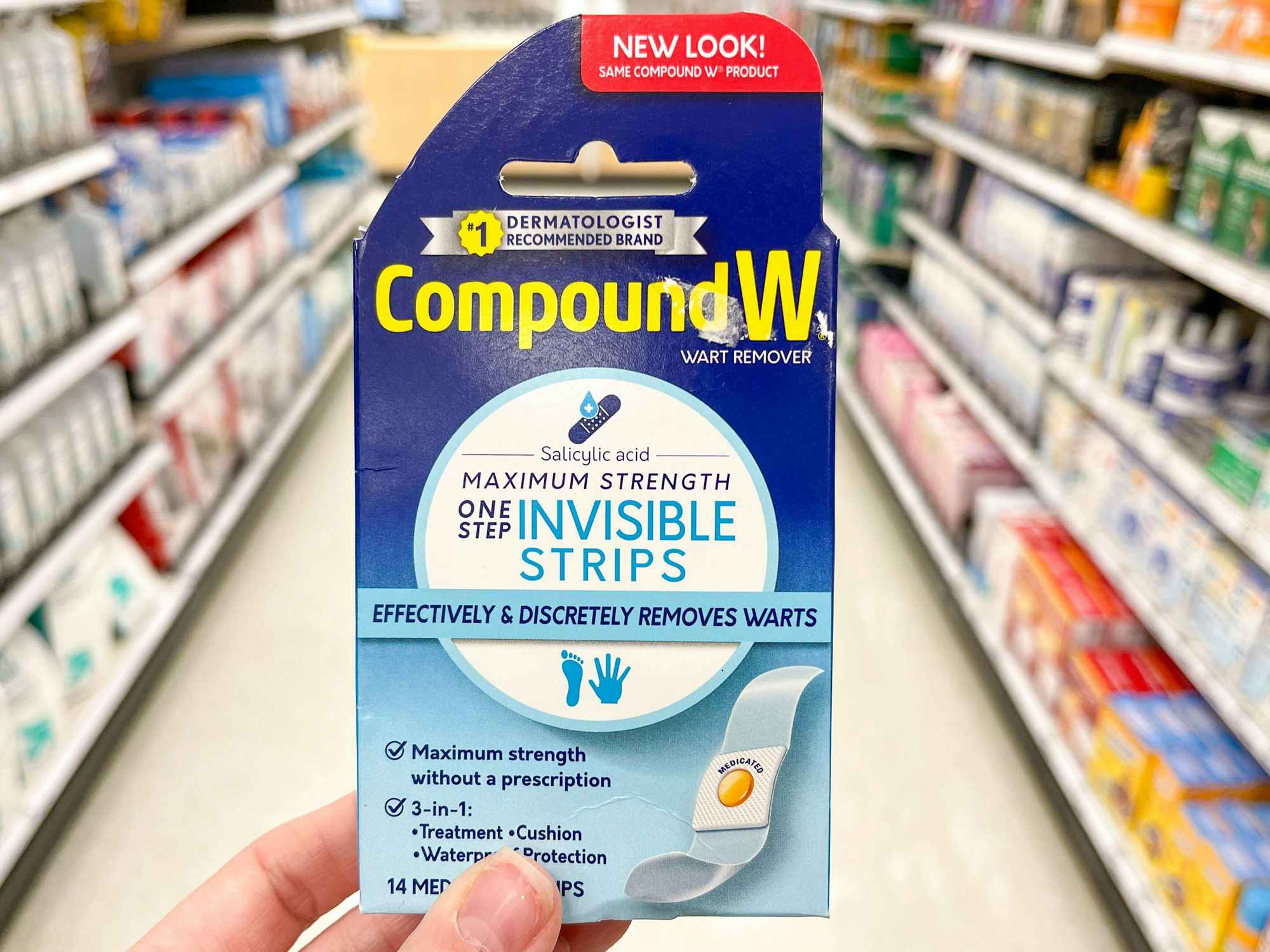 Someone holding Compound W wart remover strips in a store