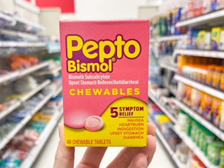 Someone holding a box of chewable Pepto Bismol tablets in a store