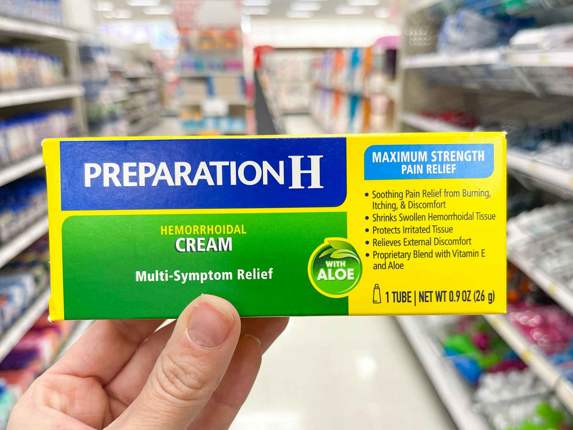 Someone holding Preparation H cream in a store