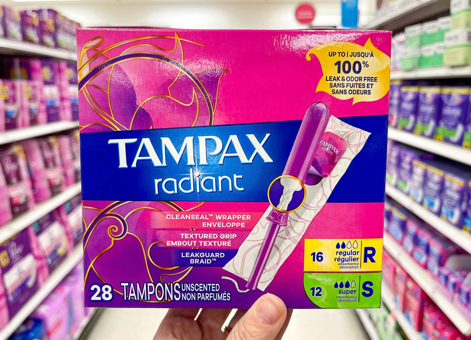 Someone holding Tampax Radiant tampons in a store